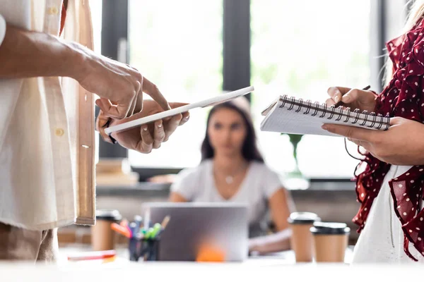 Vista recortada de los estudiantes sosteniendo portátil y tableta digital - foto de stock