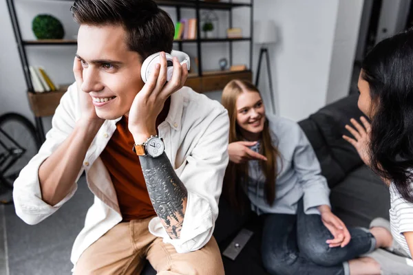 Selektiver Fokus eines gutaussehenden Mannes, der Musik mit Kopfhörern hört — Stockfoto