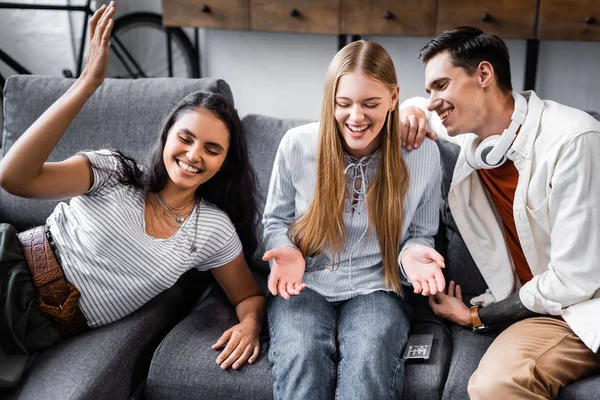 Handsome and attractive multicultural friends smiling and talking in apartment — Stock Photo