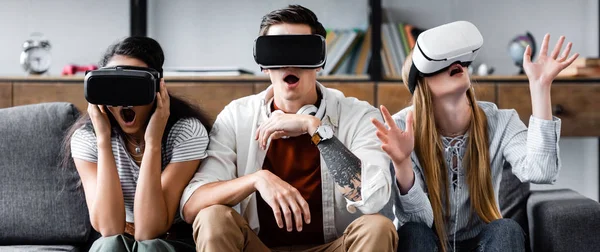 Panoramic shot of multicultural friends with virtual reality headsets — Stock Photo