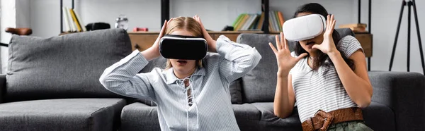 Plano panorámico de amigos multiculturales con auriculares de realidad virtual en apartamento - foto de stock