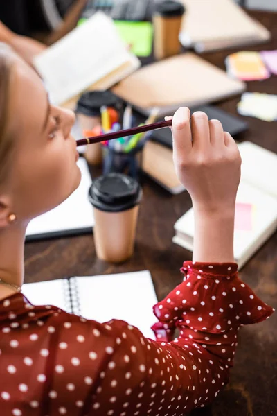 Selective focus of student in blouse holding pencil in apartment — Stock Photo