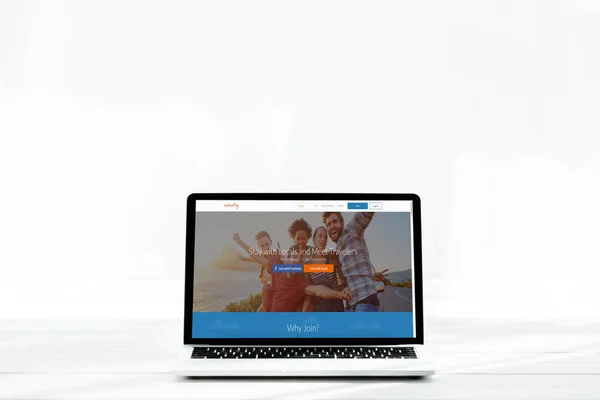 KYIV, UCRANIA - 23 de julio de 2019: portátil moderno con sitio web couchsurfing en pantalla en blanco - foto de stock