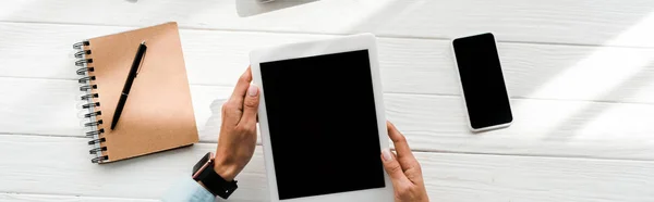 Tiro panorâmico de mulher segurando tablet digital com tela em branco perto de smartphone e notebook com caneta — Fotografia de Stock