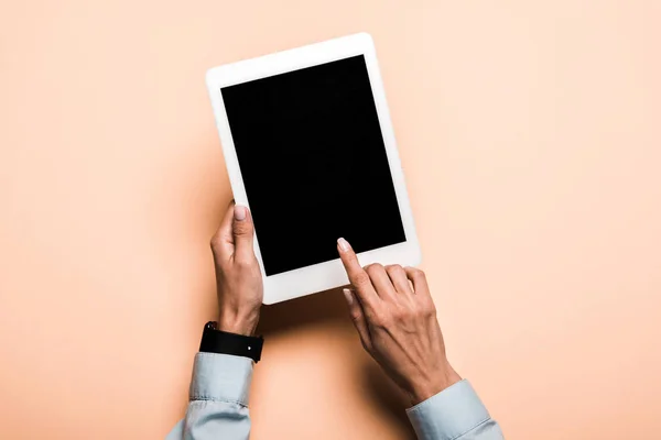 Vista recortada de la mujer apuntando con el dedo a la tableta digital con pantalla en blanco en rosa - foto de stock