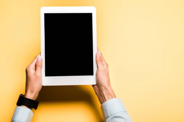 Vista recortada de la mujer sosteniendo tableta digital con pantalla en blanco en naranja - foto de stock