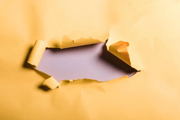 Papel naranja andrajoso y texturizado con borde enrollado en púrpura - foto de stock