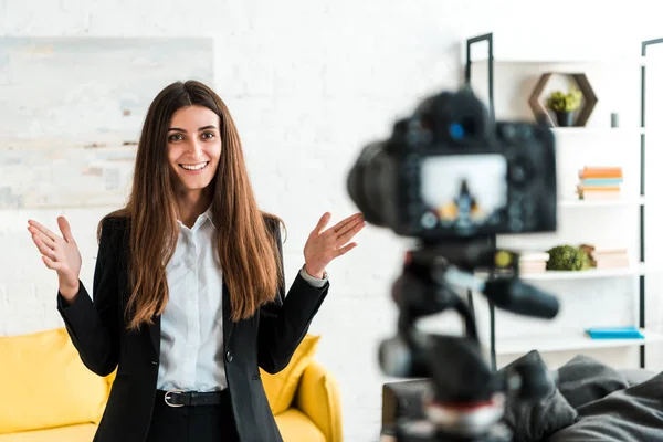 Selective focus of cheerful video blogger gesturing while looking at digital camera — Stock Photo