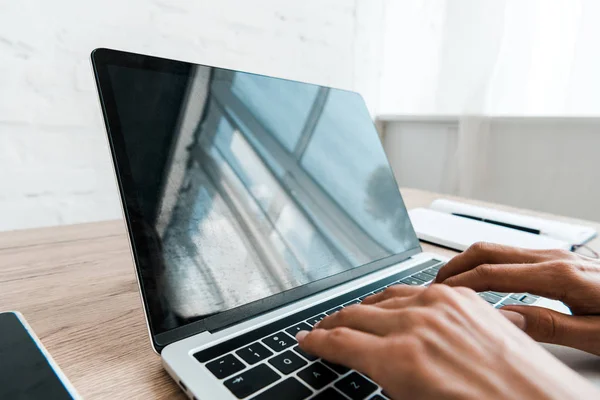 Vista recortada de la mujer escribiendo en el teclado del ordenador portátil en la oficina - foto de stock