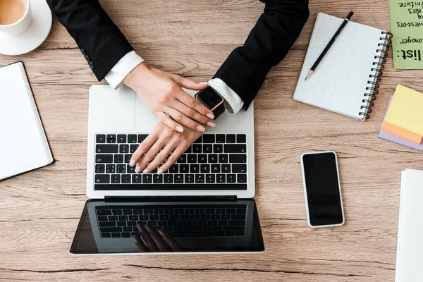 Vue de dessus de la femme d'affaires près de gadgets avec des écrans bancaires et une tasse de café au bureau — Photo de stock