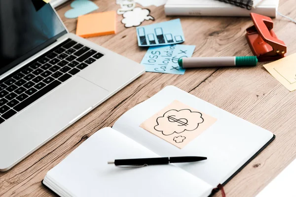 Enfoque selectivo de cuaderno y pluma cerca de la computadora portátil y notas adhesivas - foto de stock