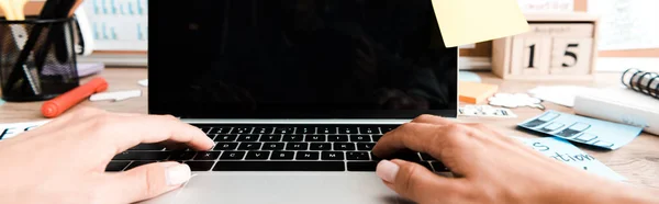 Panoramic shot of woman using laptop with blank screen near sticky notes — Stock Photo