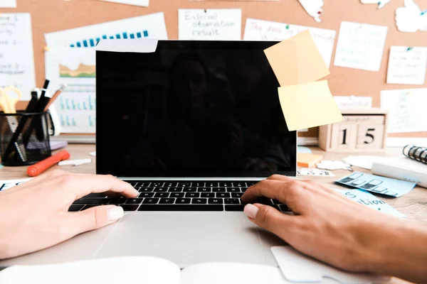 Cropped view of woman using laptop with blank screen near sticky notes — Stock Photo