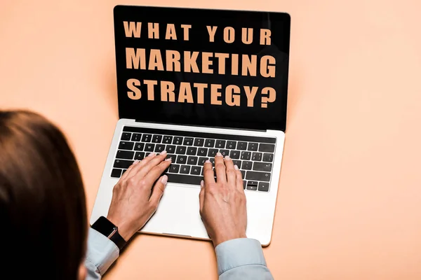 Vista cortada de mulher digitando no laptop com o que sua estratégia de marketing lettering em rosa — Fotografia de Stock