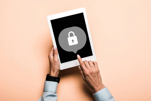 Cropped view of woman pointing with finger at digital tablet with padlock on screen on pink — Stock Photo