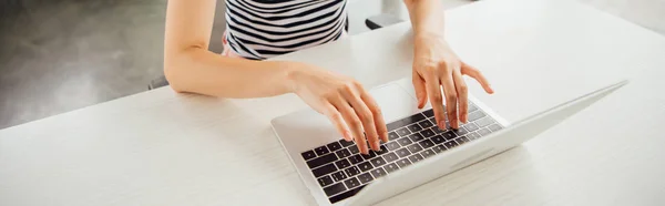 Tiro panorâmico de menina em t-shirt listrada usando laptop em casa — Fotografia de Stock