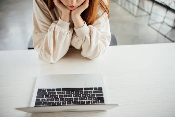 Partial view of girl sitting at table with laptop at home — Stock Photo