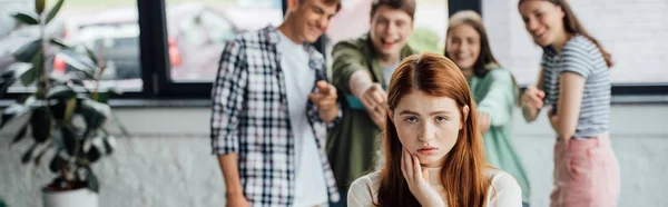 Panoramic shot of group of teenagers bullying girl — Stock Photo