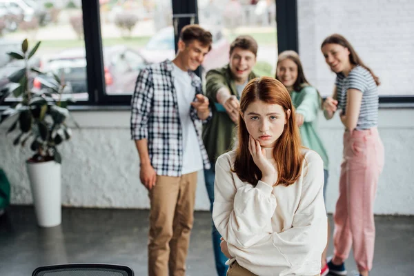 Избирательный фокус группы подростков, издевающихся над грустной девушкой — стоковое фото
