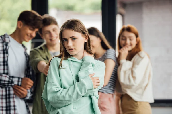 Панорамный снимок группы подростков, издевающихся над девушкой — стоковое фото