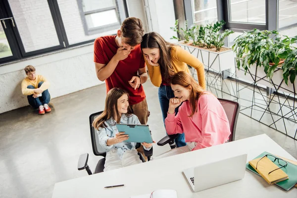 Gruppe lächelnder Schüler mit digitalem Tablet im Klassenzimmer — Stockfoto