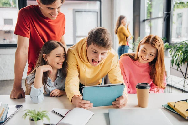 Gruppe lächelnder Schüler mit digitalem Tablet im Klassenzimmer — Stockfoto