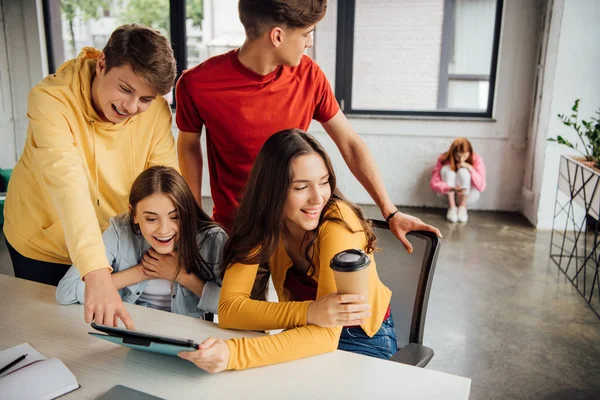 Groupe d'écoliers souriants utilisant une tablette numérique en classe — Photo de stock