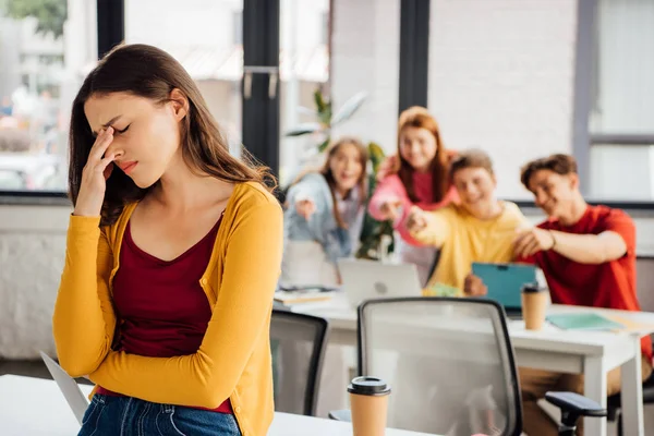 Triste fille et rire écoliers pointant avec les doigts vers elle — Photo de stock