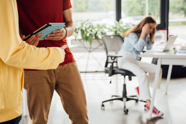 Vista parziale di ragazzi che utilizzano tablet digitale e ragazza seduta alla scrivania e utilizzando il computer portatile — Foto stock