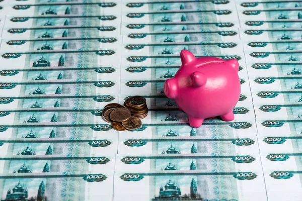 Alcancía rosa cerca de monedas metálicas en dinero ruso - foto de stock