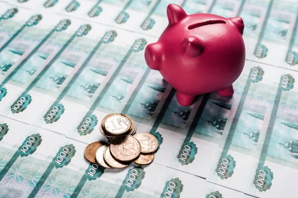 Selective focus of piggy bank near metallic coins on russian money — Stock Photo
