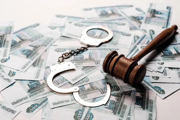 Selective focus of gavel near metallic handcuffs on russian money — Stock Photo