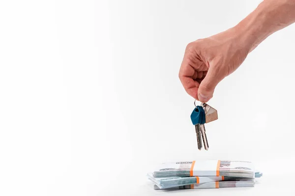 Cropped view of man holding keys near stacks with russian money isolated on white — Stock Photo