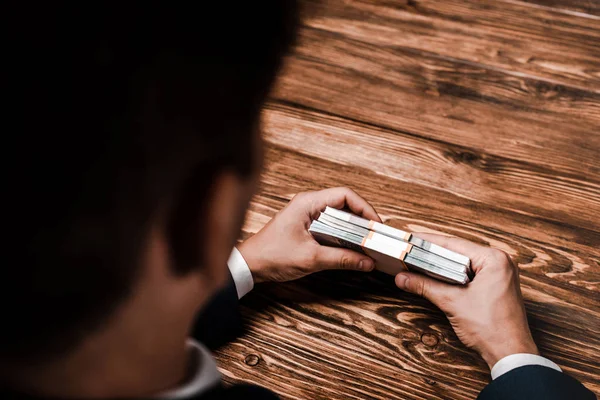 Overhead view of man holding russian money near wooden table — Stock Photo