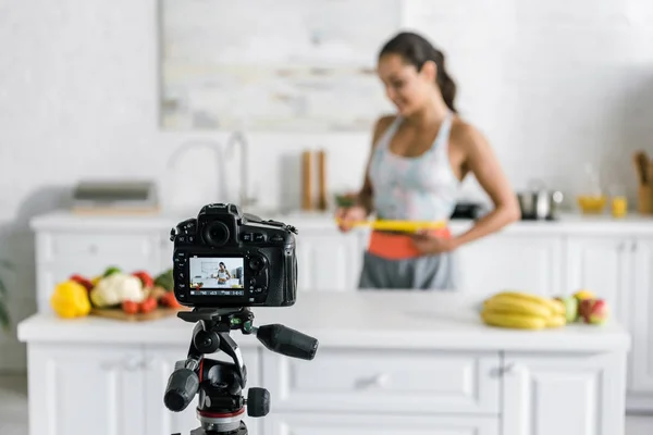 Mise au point sélective de l'appareil photo numérique avec femme mesurant la taille à l'écran — Photo de stock