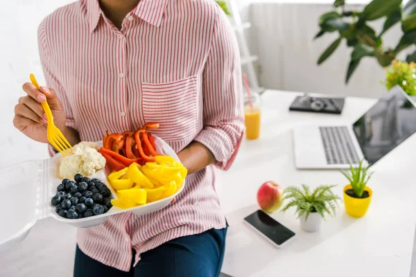 Обрезанный вид женщины, держащей пищевой контейнер с вкусной едой — стоковое фото