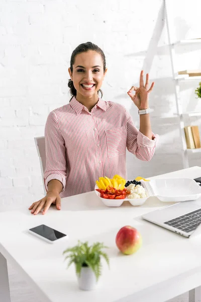 Вибірковий фокус щасливої дівчини, що показує знак ОК біля смачних овочів — стокове фото