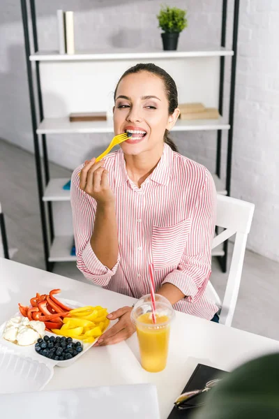 Fröhliche Frau hält Plastikgabel mit Paprika — Stockfoto