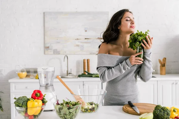 Привлекательная девушка, нюхающая мяту рядом с овощами — стоковое фото