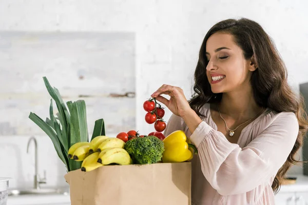 Glückliche junge Frau mit roten Kirschtomaten — Stockfoto