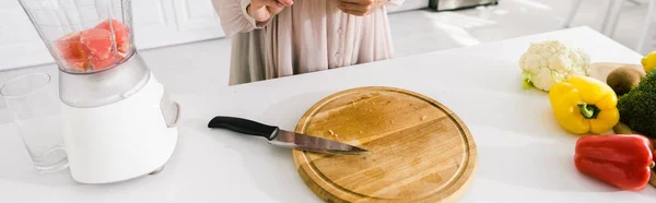 Tiro panorámico de mujer embarazada cerca de licuadora con pomelo - foto de stock