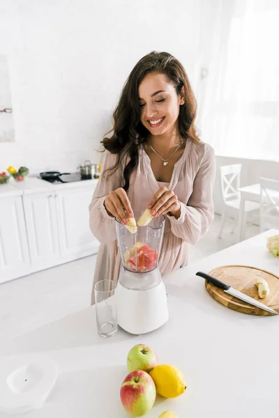 Mulher grávida feliz colocando banana no liquidificador com toranja — Fotografia de Stock