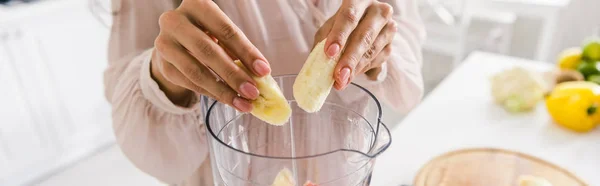 Colpo panoramico di donna che mette banane affettate nel frullatore — Foto stock