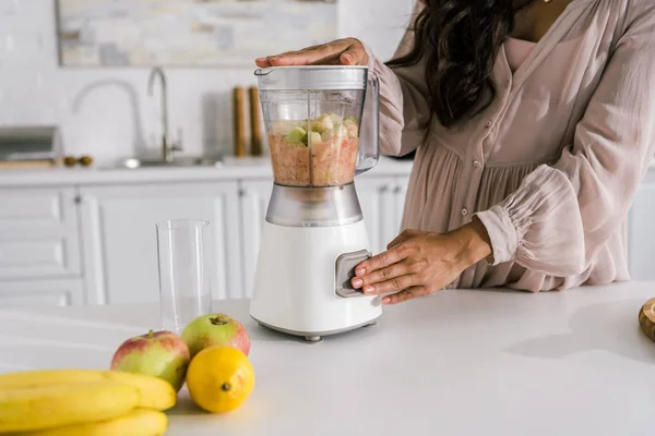 Cropped view of pregnant woman preparing smoothie in blender — Stock Photo