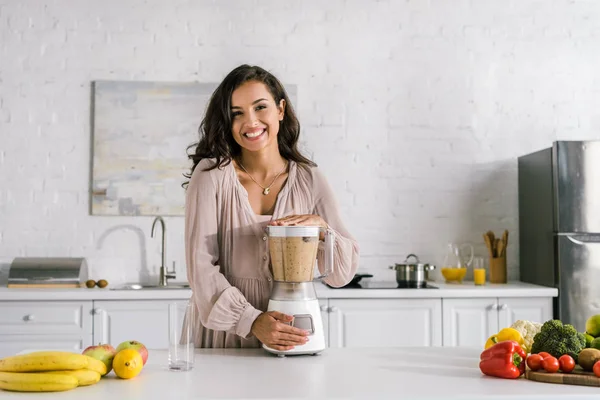 Happy pregnant woman standing near blender with smoothie — Stock Photo