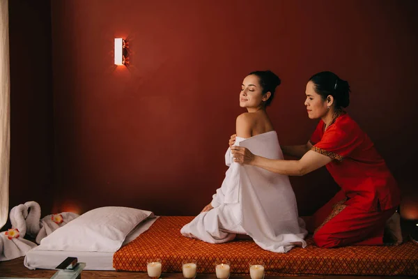 Asian woman wrapping with towel attractive woman in spa salon — Stock Photo