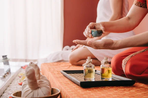 Vue recadrée du masseur versant l'huile de parfum sur la main — Photo de stock