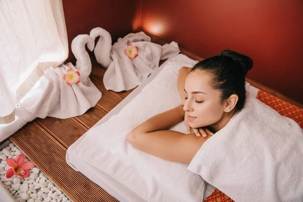 Attractive woman with closed eyes lying on massage mat — Stock Photo