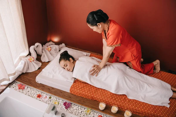 Vista ad alto angolo del massaggiatore facendo massaggio alla donna attraente — Foto stock