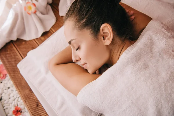 Mulher atraente com olhos fechados deitado no tapete de massagem — Fotografia de Stock